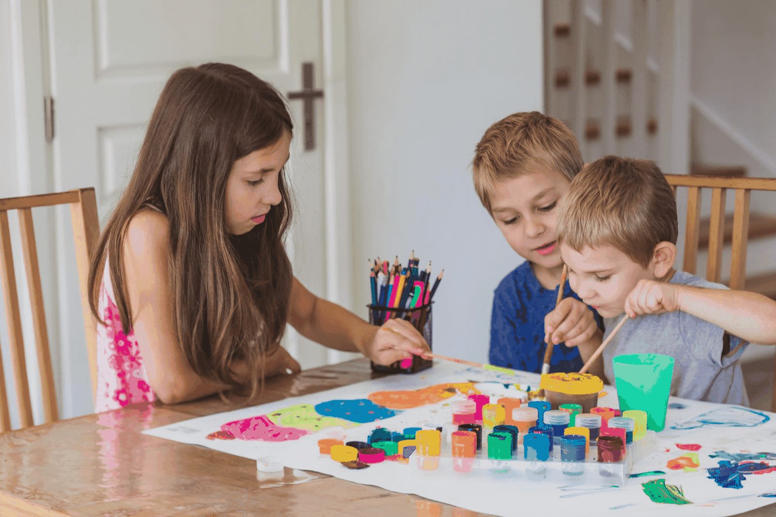 Children painting at a table, the kind of children's products CPSIA covers