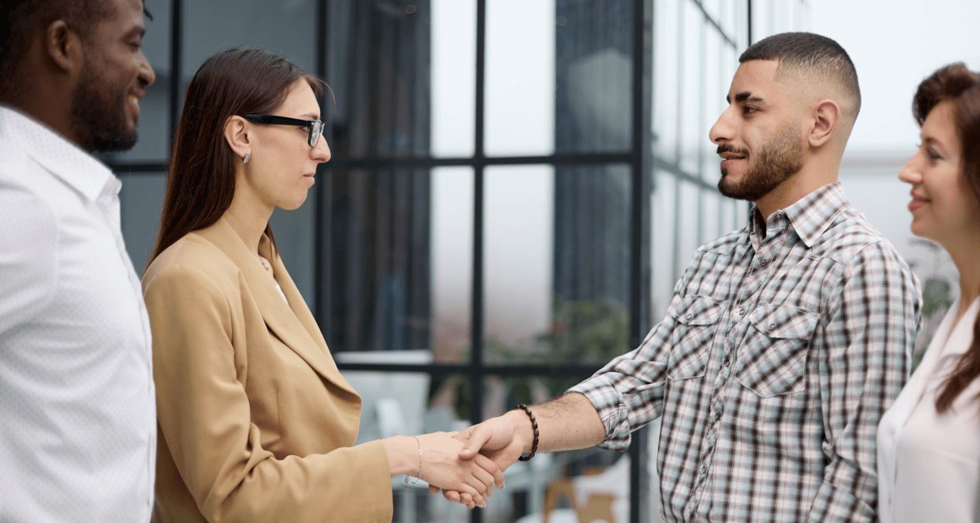 A buyer and a supplier shaking hands at a meeting